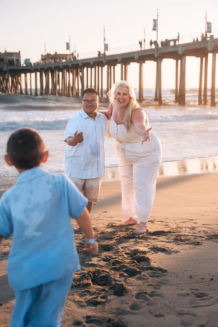 Mom and Dad waiting with open arms at Huntington Beach Pier as their son sets off across the sand