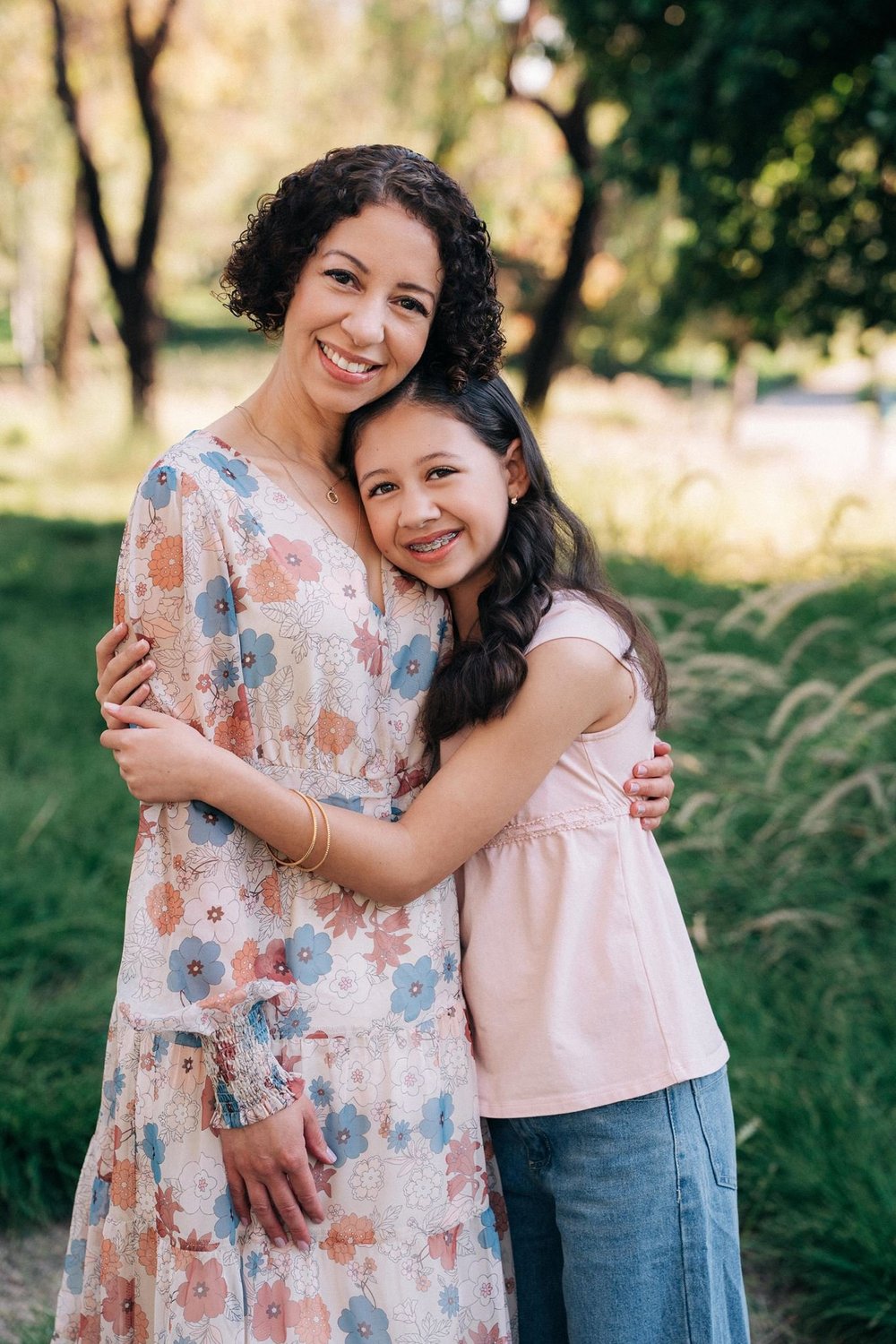 A daughter hugging her mom during a family session in the park