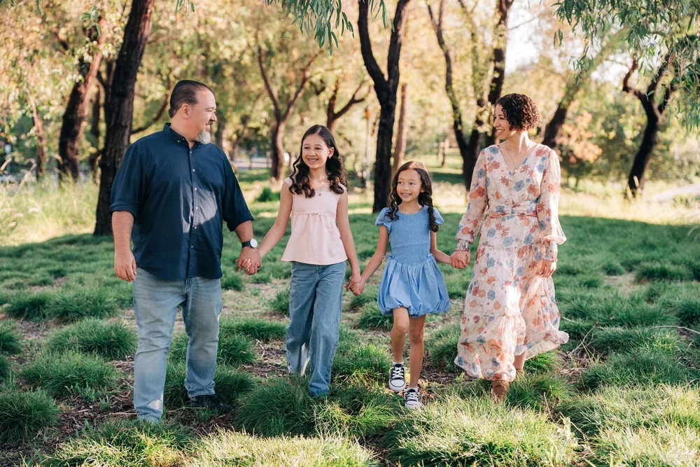The Slemmons family walking hand in hand under the trees at Jeffrey Open Space Trail in Irvine