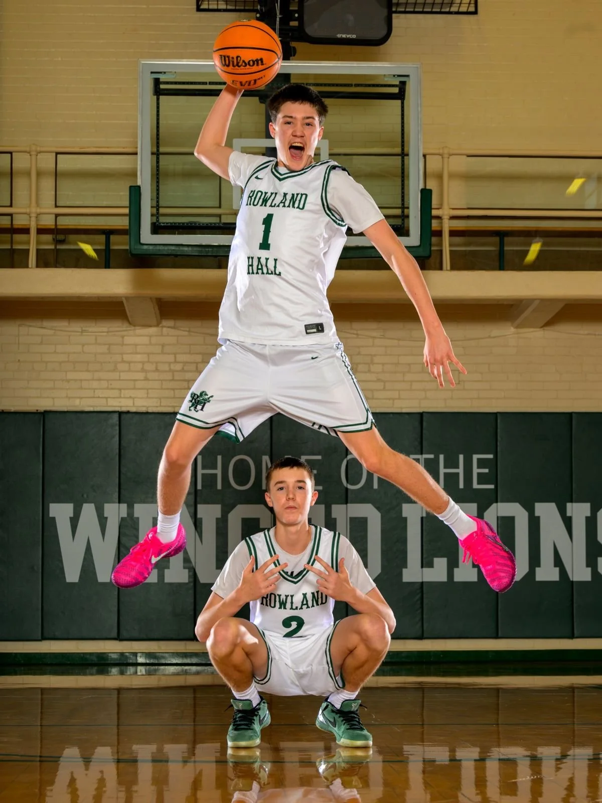 Jrue Miller leaps over his brother Jevin in the Rowland Hall gym