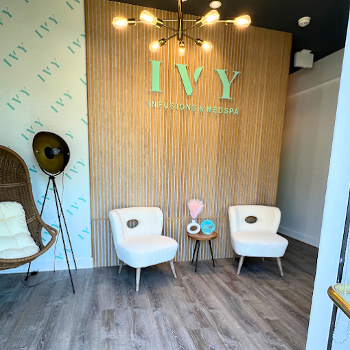 IVY’s reception area, with white chairs and a wood-paneled brand wall