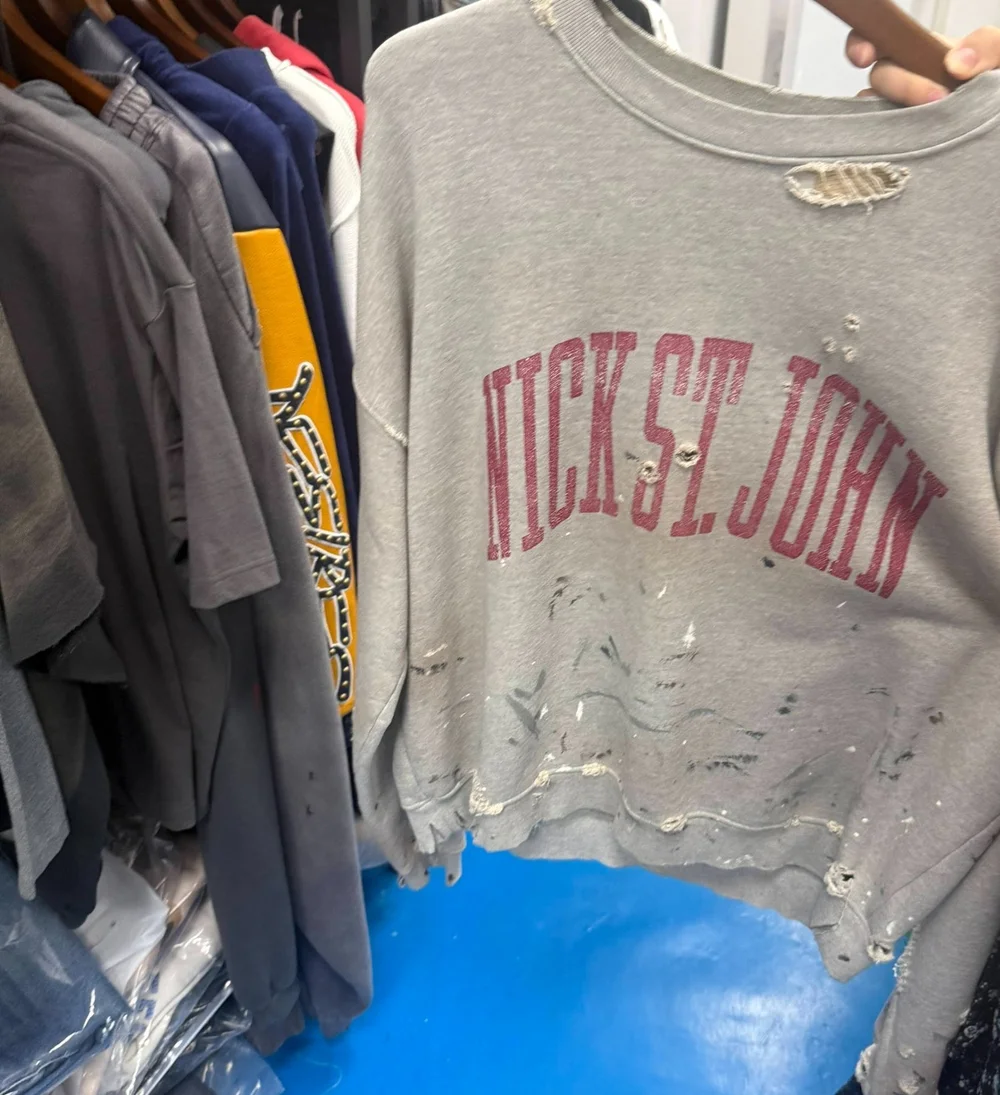 Distressed gray crewneck sample with faded burgundy lettering and worn detailing