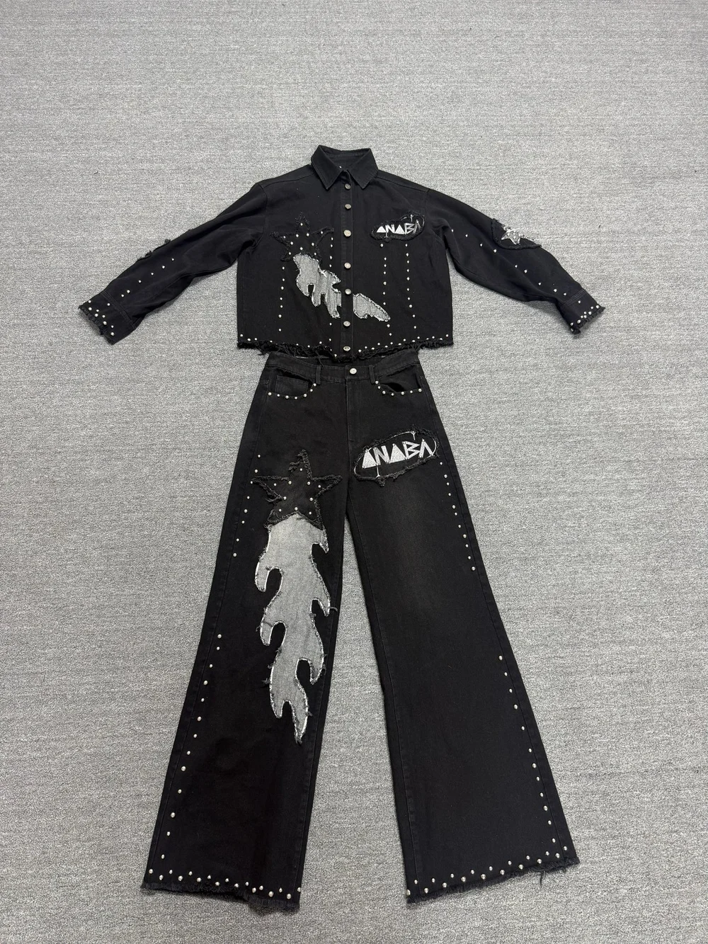 Black jacket and trousers with distressed patches and metal stud detailing