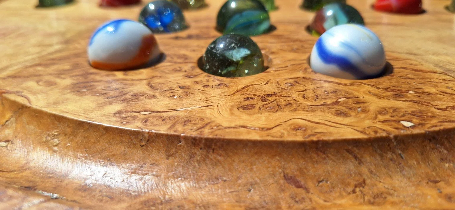Coloured marbles set into a figured timber games table