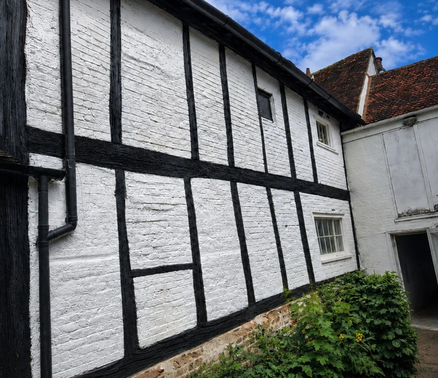 Finished white masonry and dark timber-framed exterior