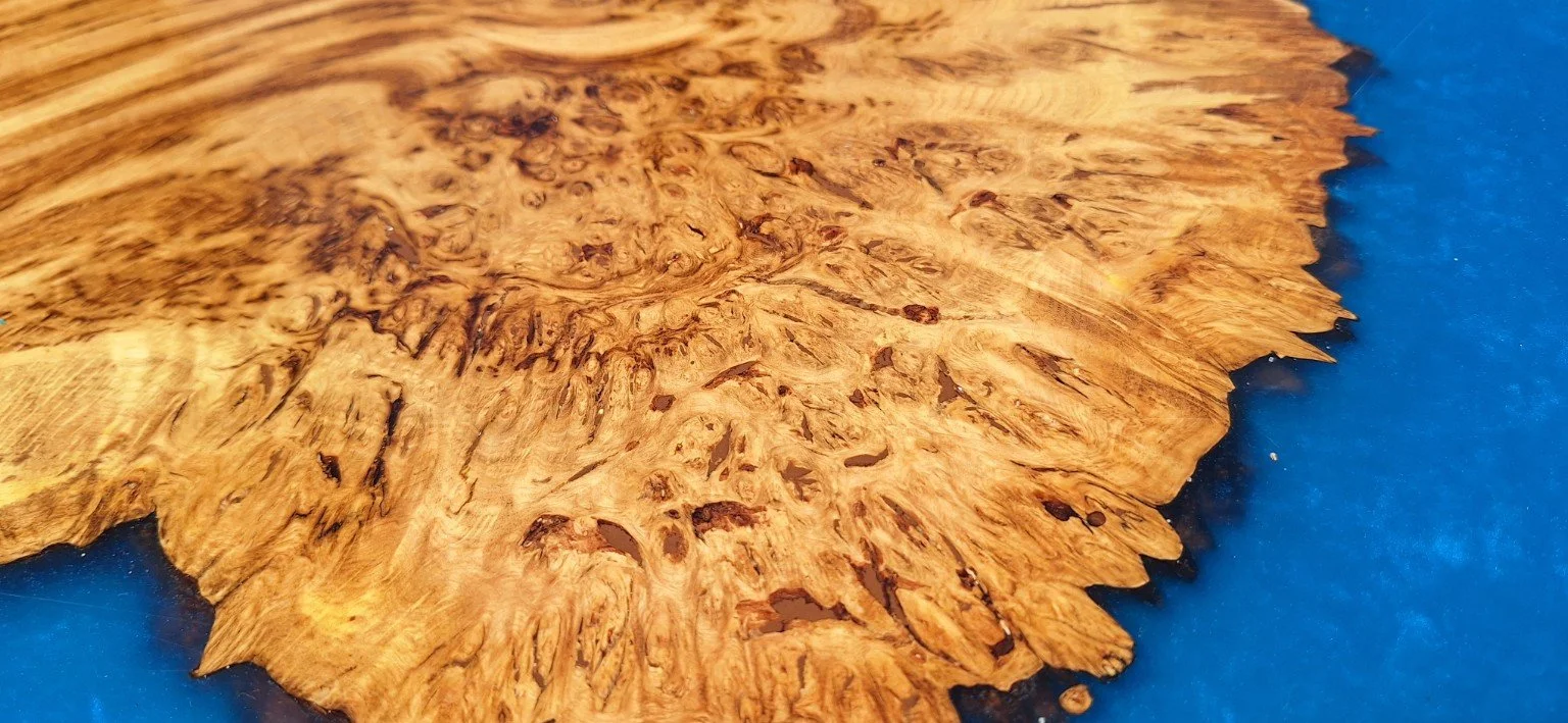 Close-up of the figured timber meeting the blue resin