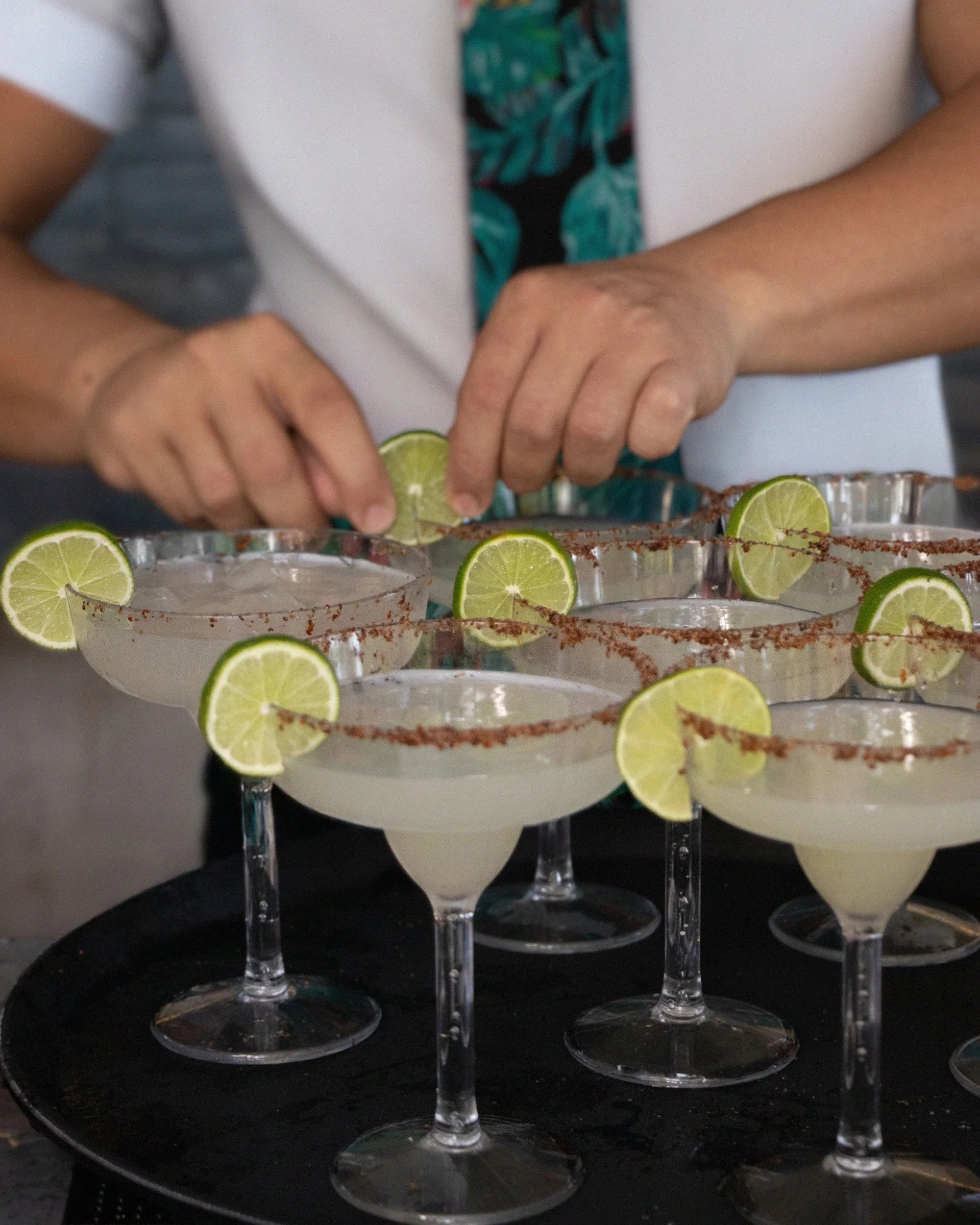 Adding lime garnish to margaritas