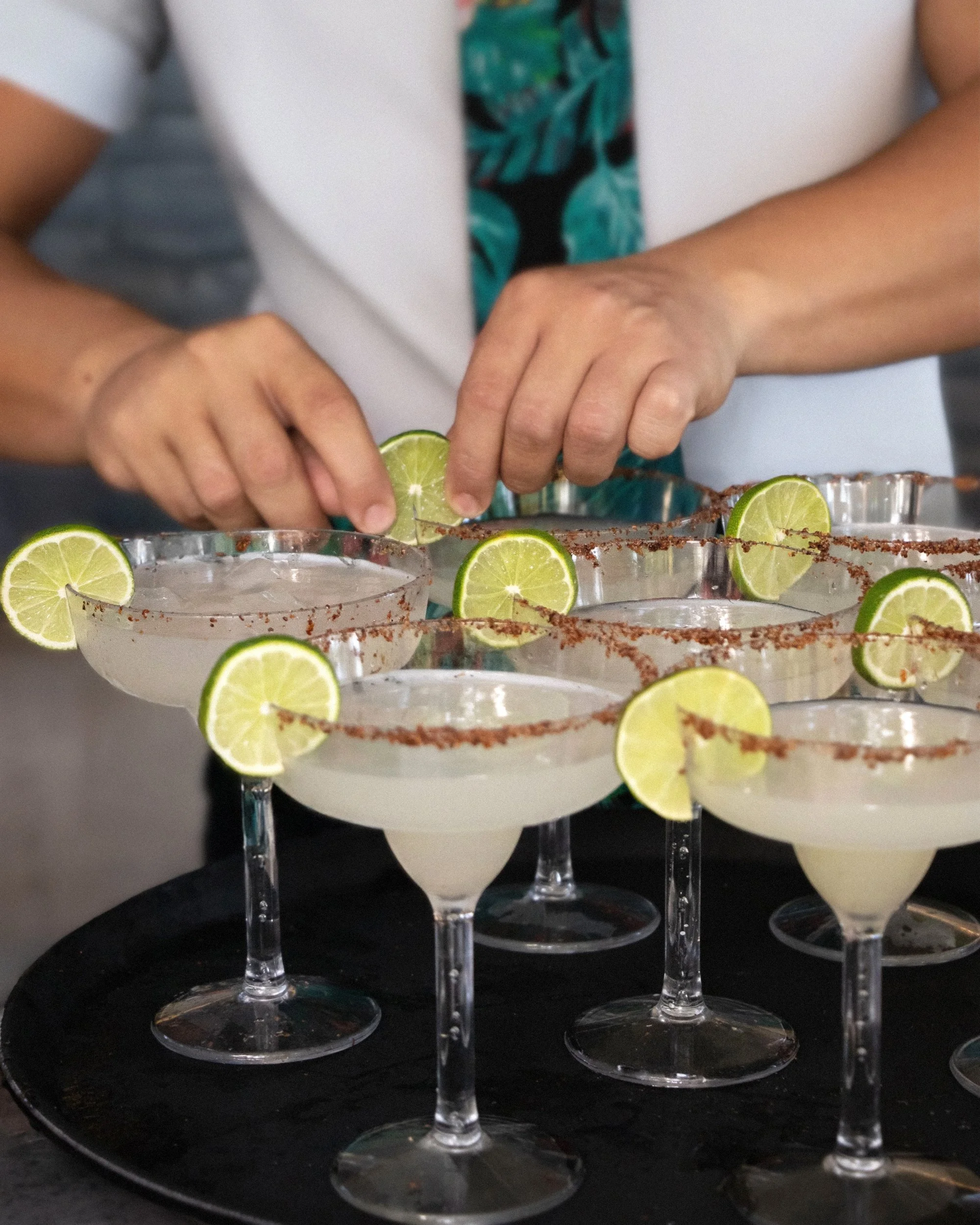 Adding lime garnish to margaritas