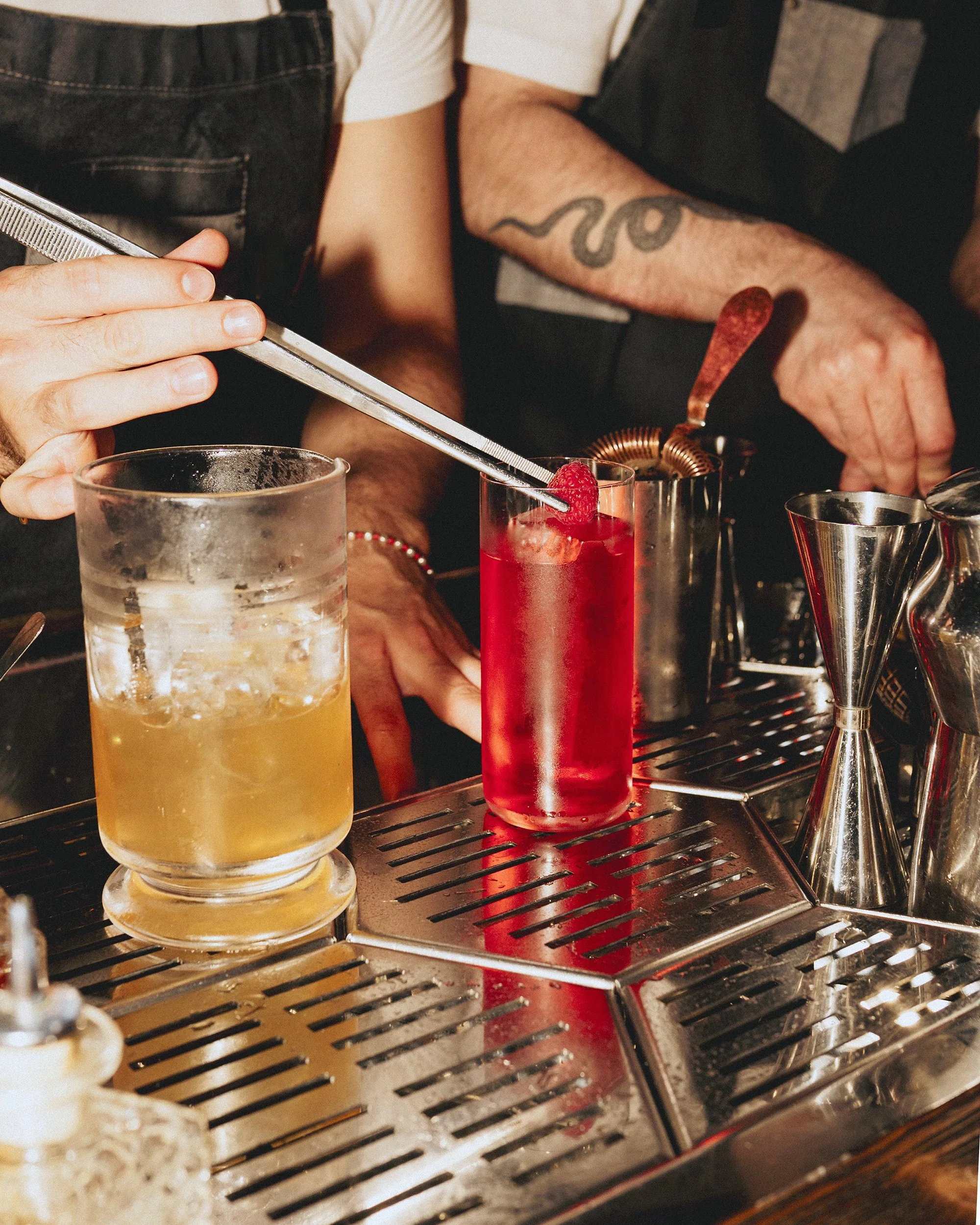 Adding raspberry garnish to a cocktail