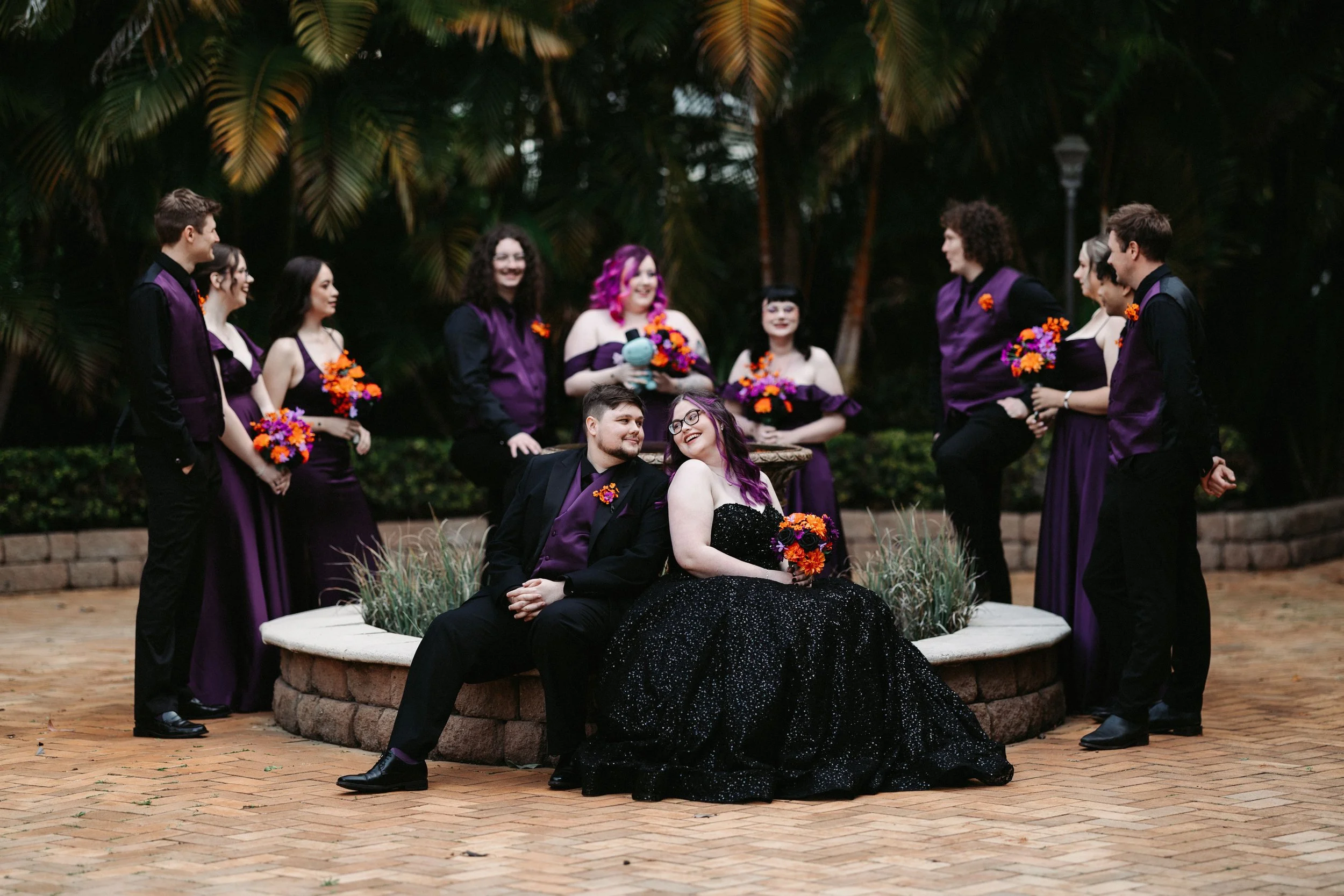 Chantel and Baylee sharing time with their wedding party beside the garden fountain at Shambala Estate.