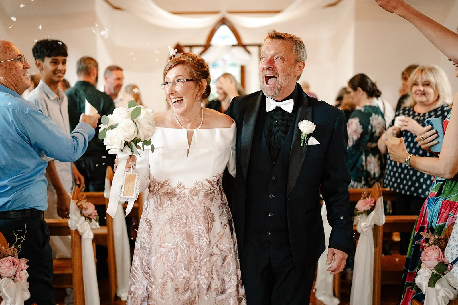 A newly married couple walking down the aisle together in the Chapel at Shambala Estate.