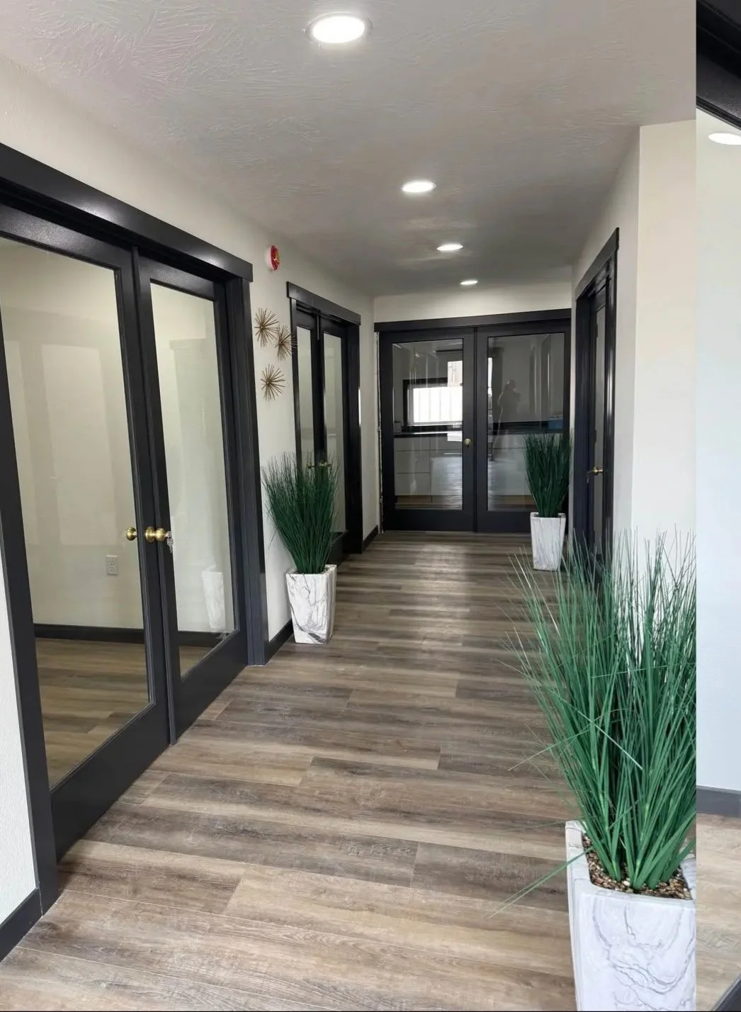 Hallway with private suite glass doors