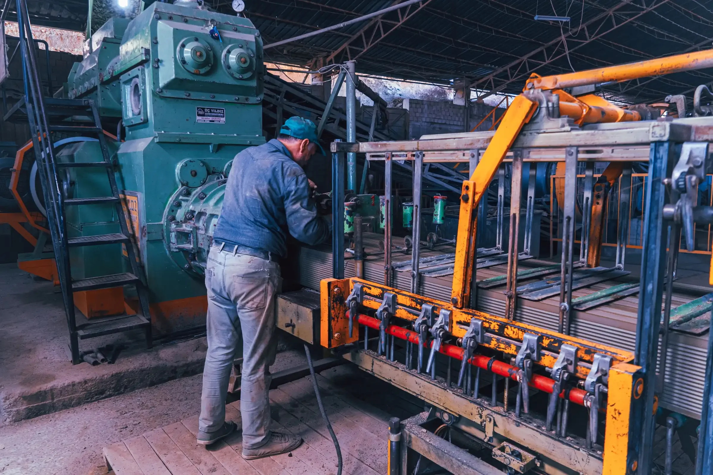 Opérateur au travail sur une machine industrielle dans un atelier de fabrication.