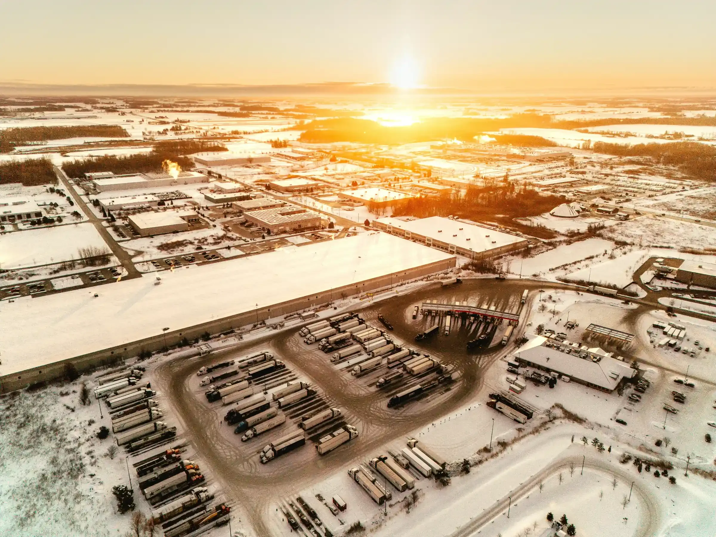 Vue aérienne d’un parc industriel enneigé au coucher du soleil, photographié par LEDC.