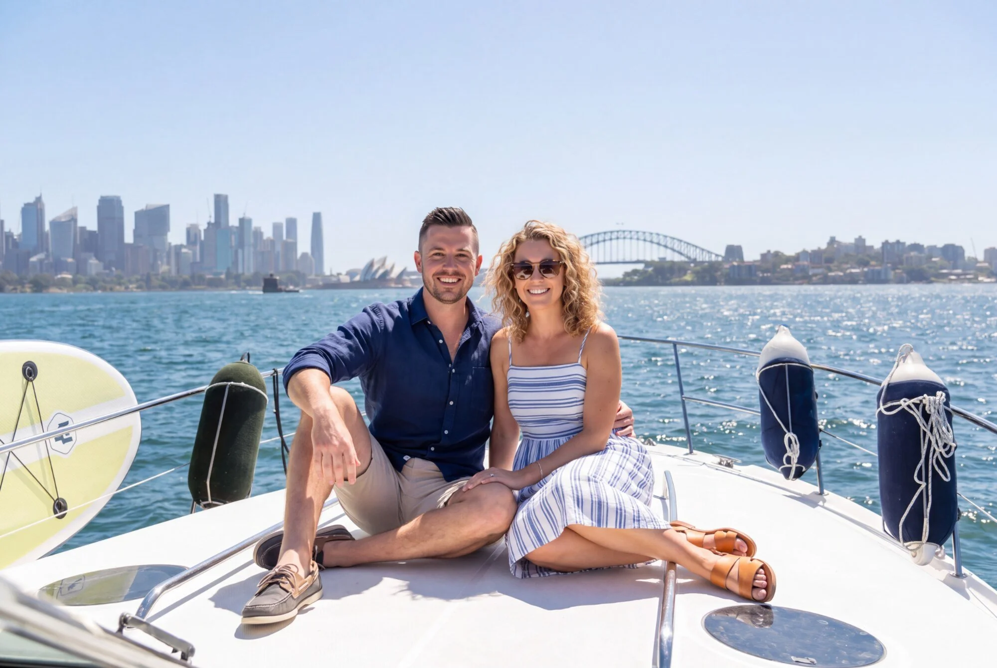 Couple relaxing on the bow with the Sydney skyline behind them