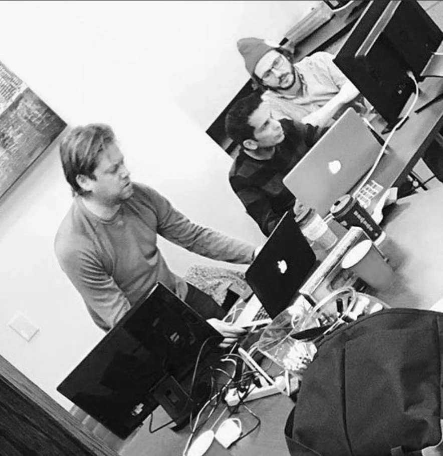 Abe working with colleagues around a table with laptops.