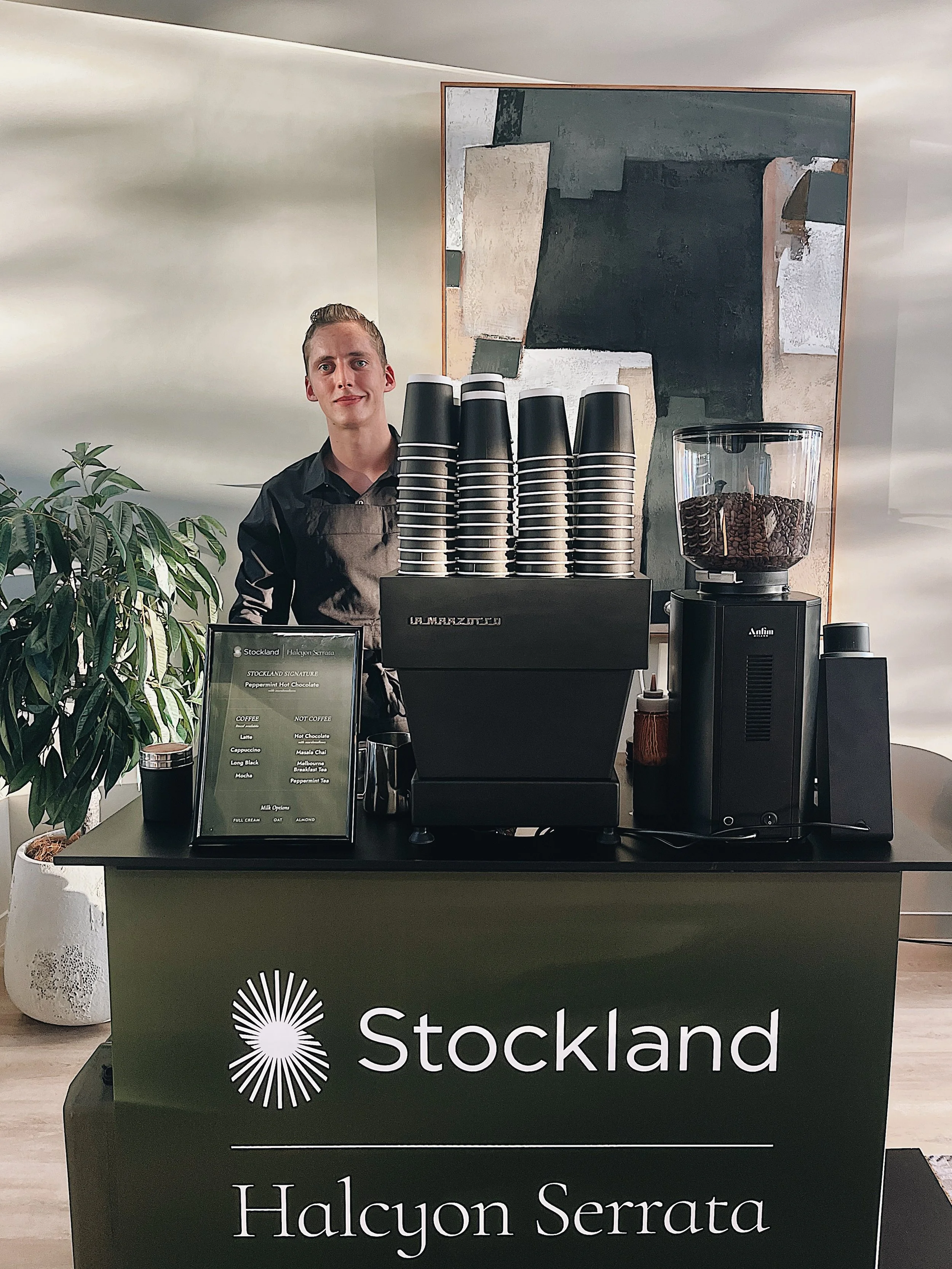Barista behind a custom branded coffee cart