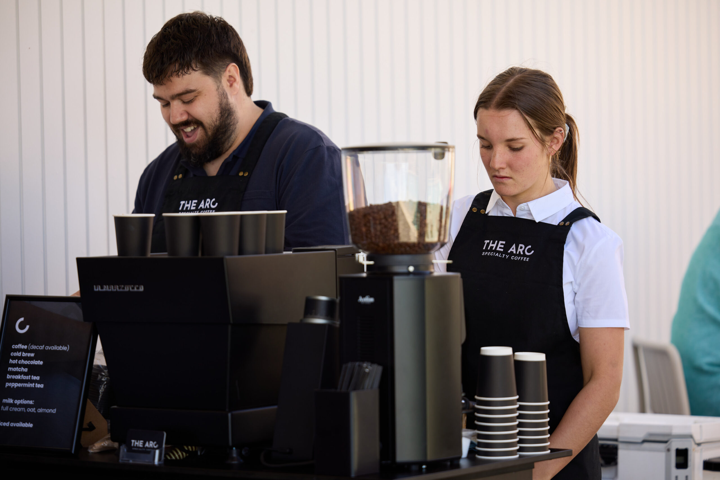 Two baristas making specialty coffee for a Brisbane office team