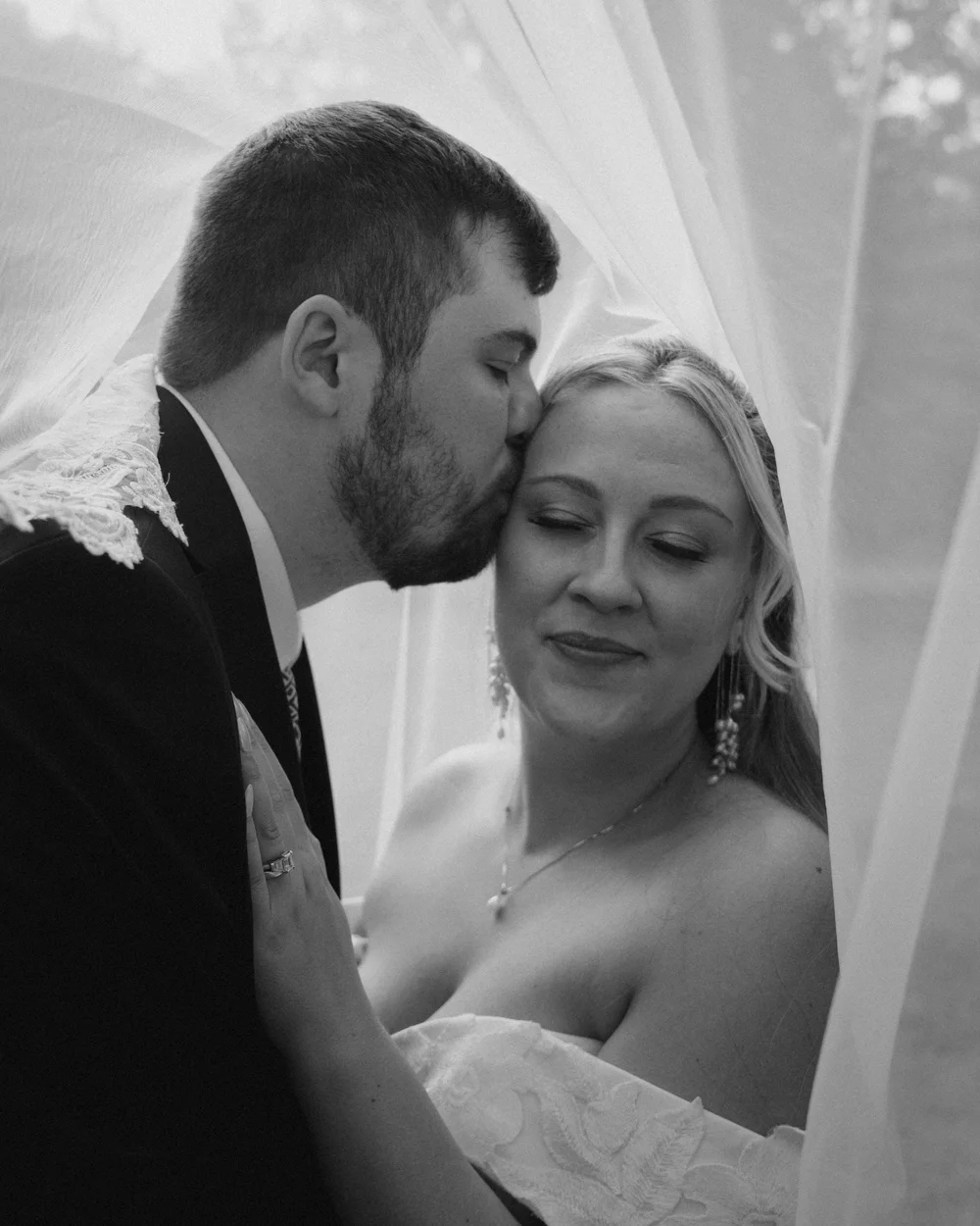 A quiet embrace beneath the wedding veil.