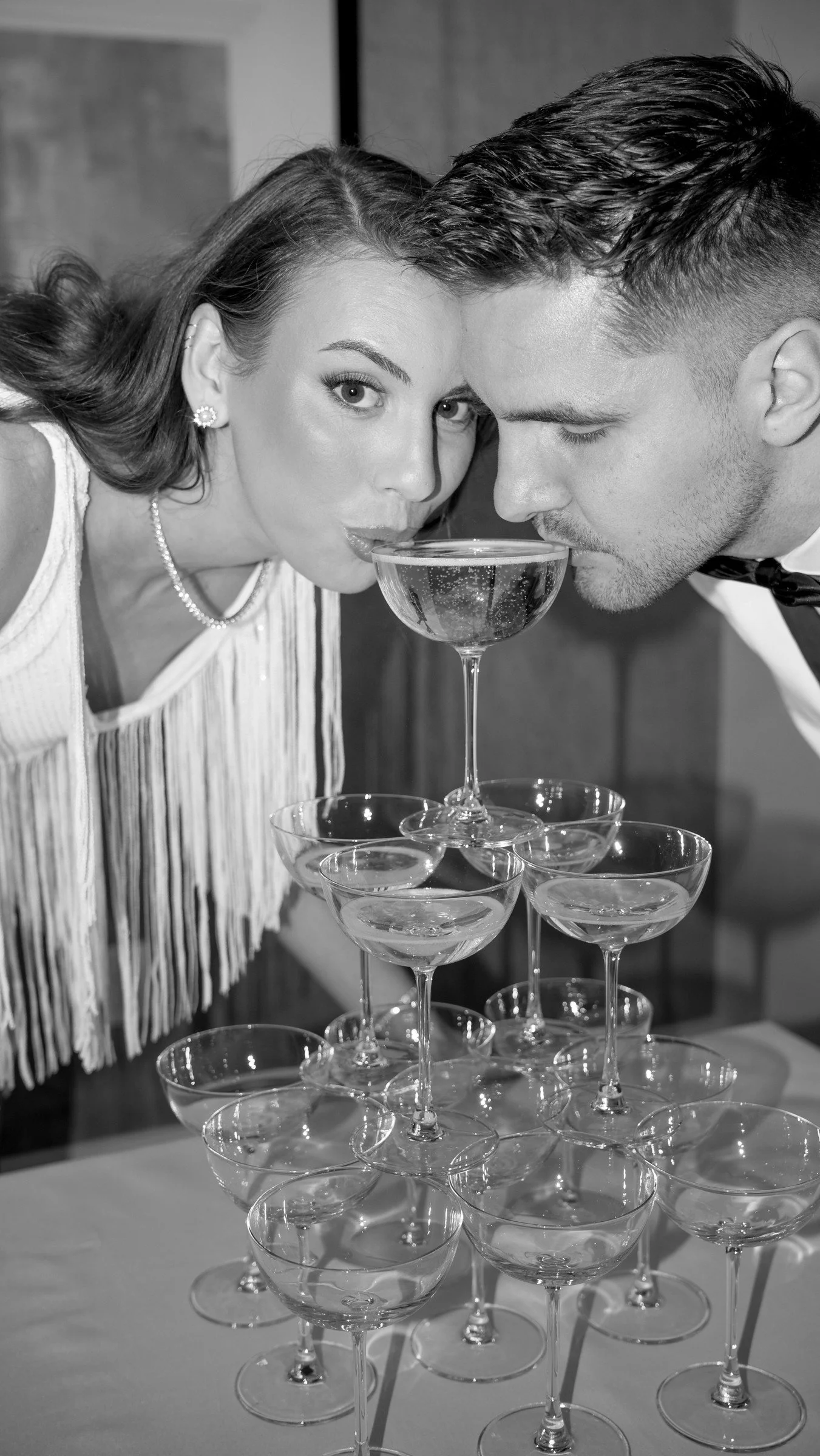 Newlyweds celebrating beside a champagne tower