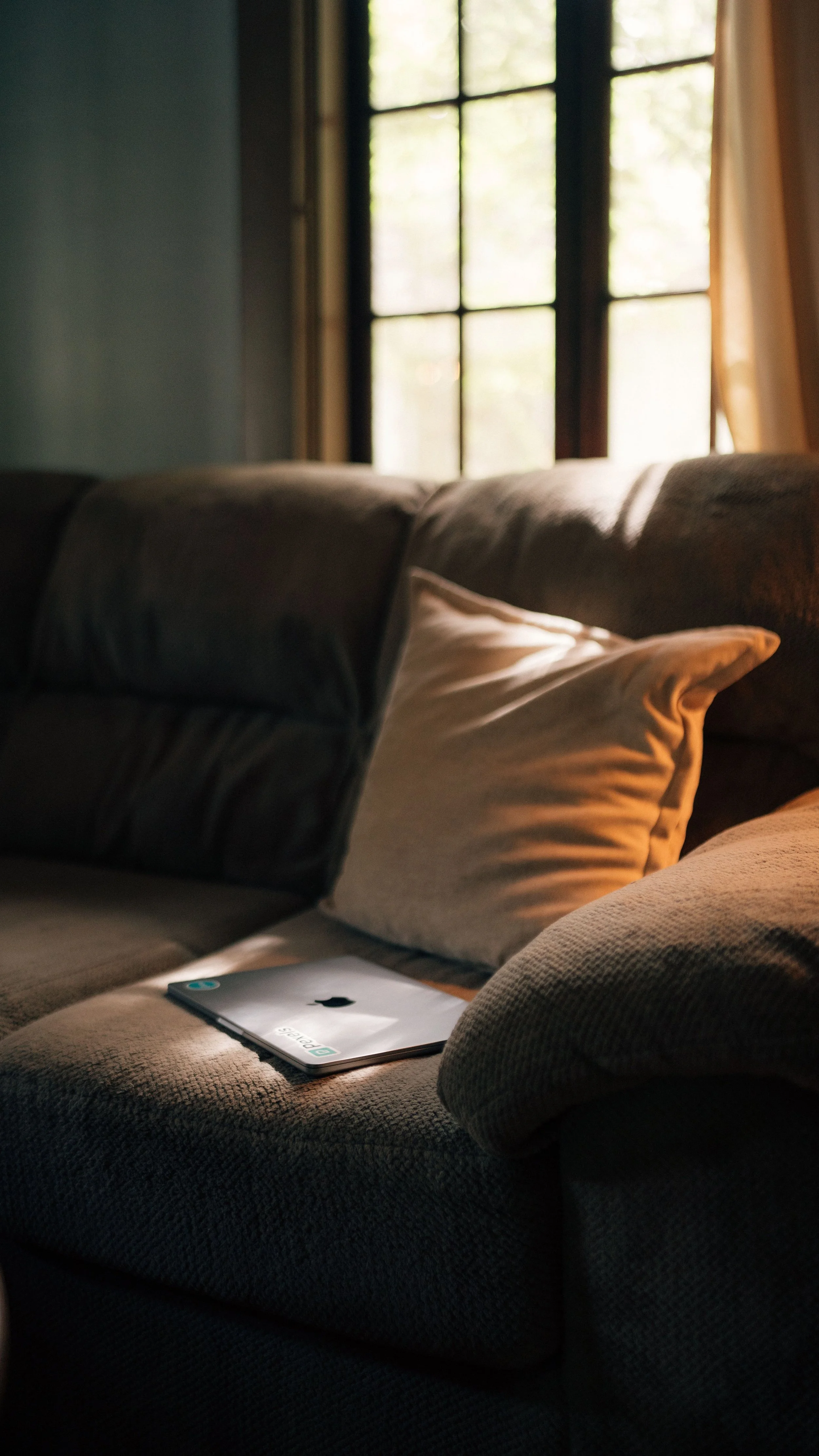 Warm, sunlit therapy space with a couch and laptop