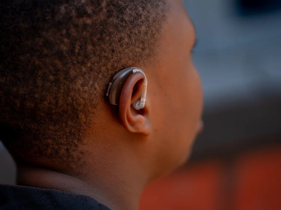 Audiologist servicing a hearing aid