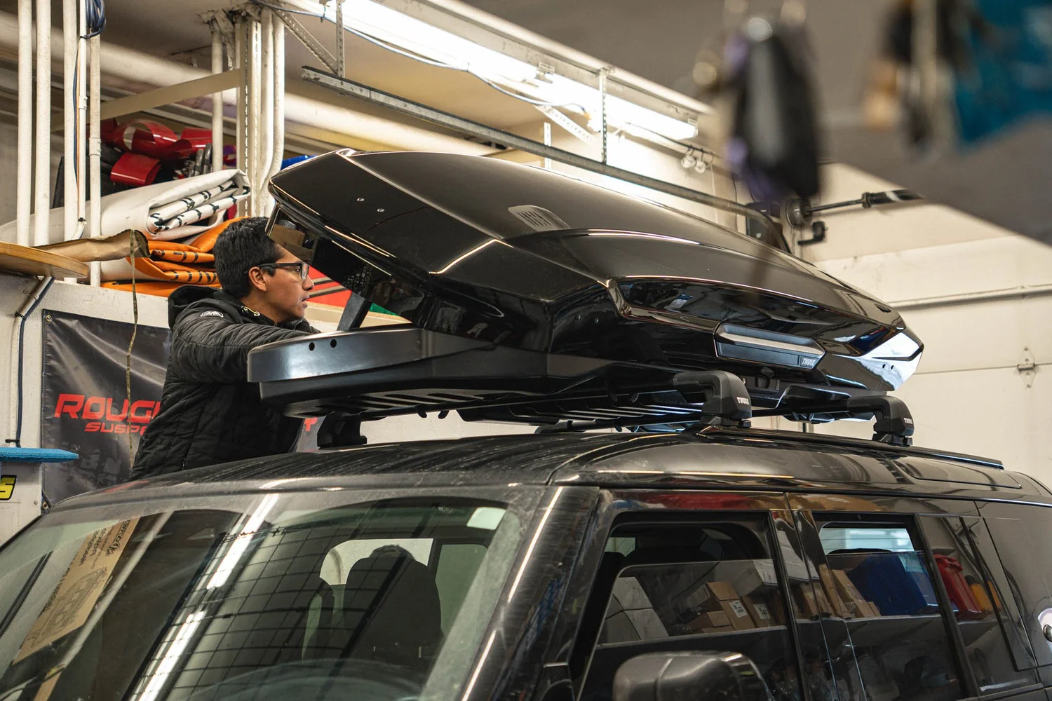 Cracks & Racks installing a Thule cargo box in the shop