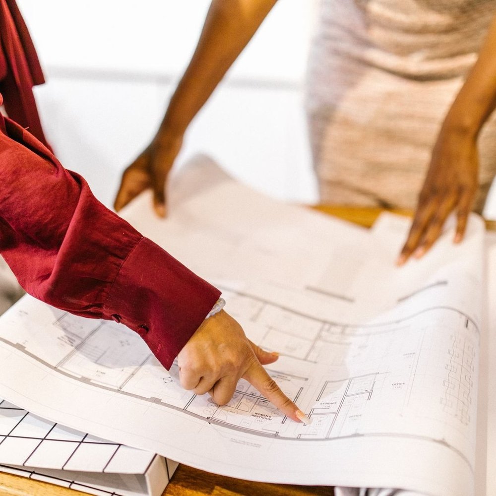 Two architects planning together over a set of building drawings