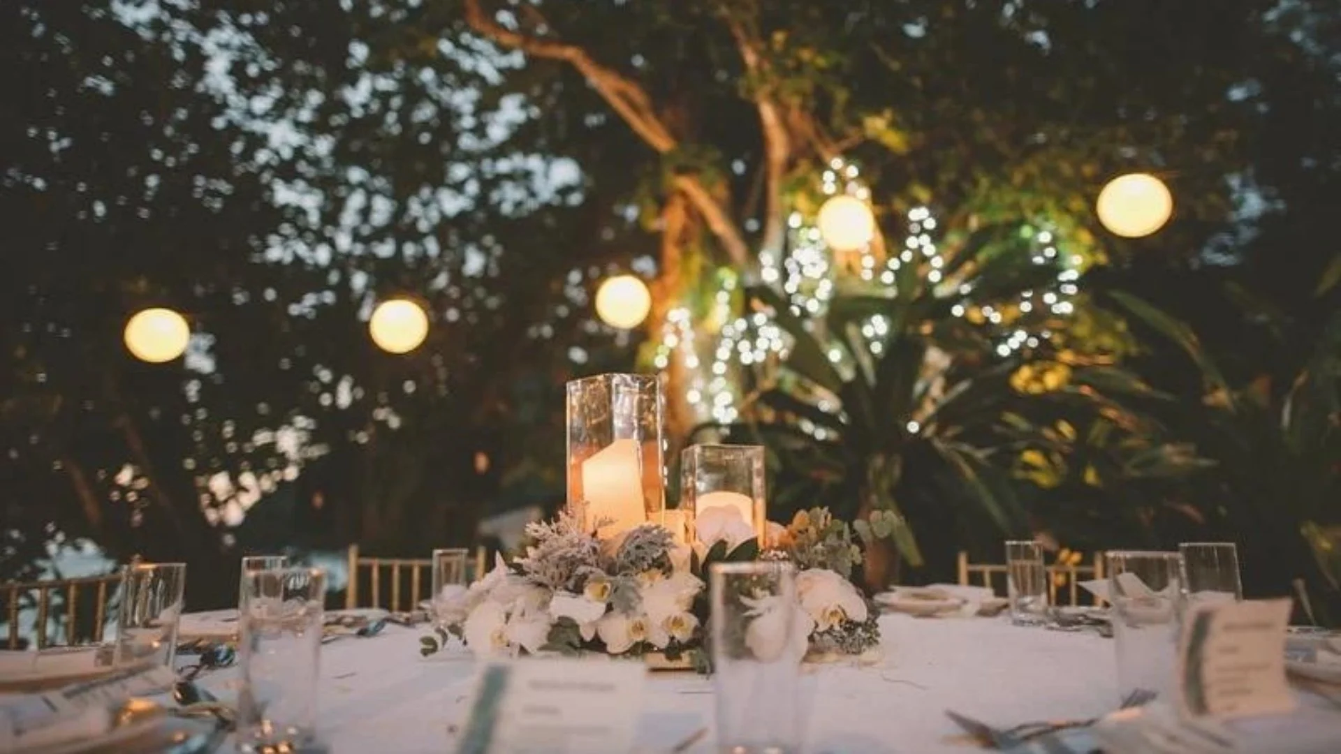 Candlelit outdoor wedding reception with string lights and a floral centerpiece — captured by The Wedded Company to reflect effortless, modern romance.