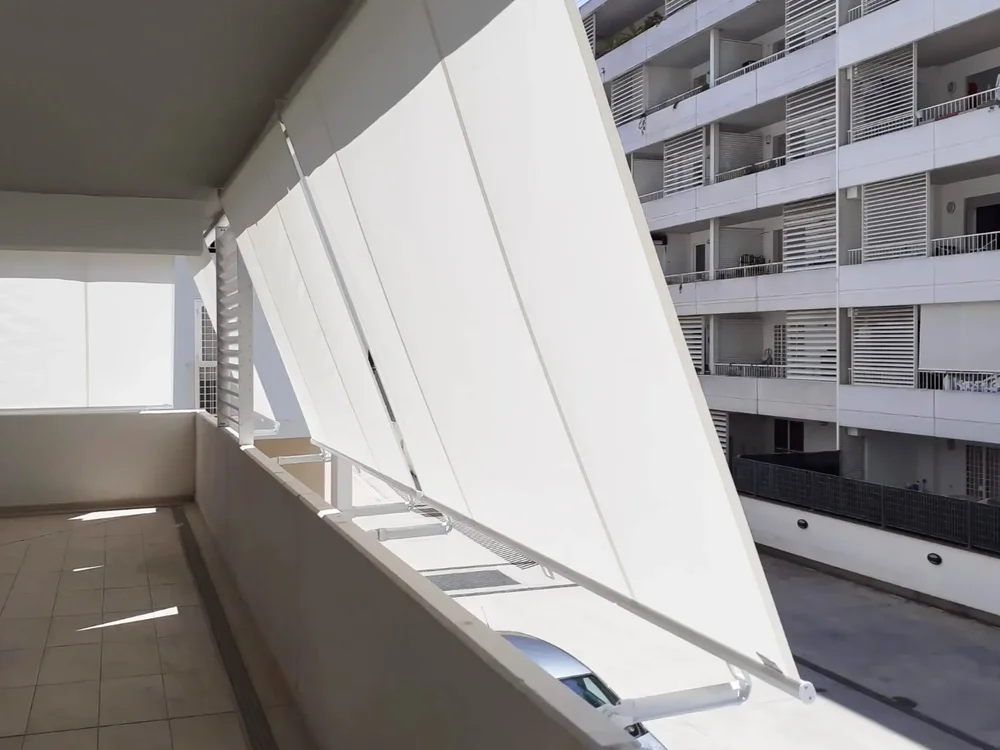 Balcone ombreggiato da tende da sole a caduta bianche fisse in tessuto Tempotest.