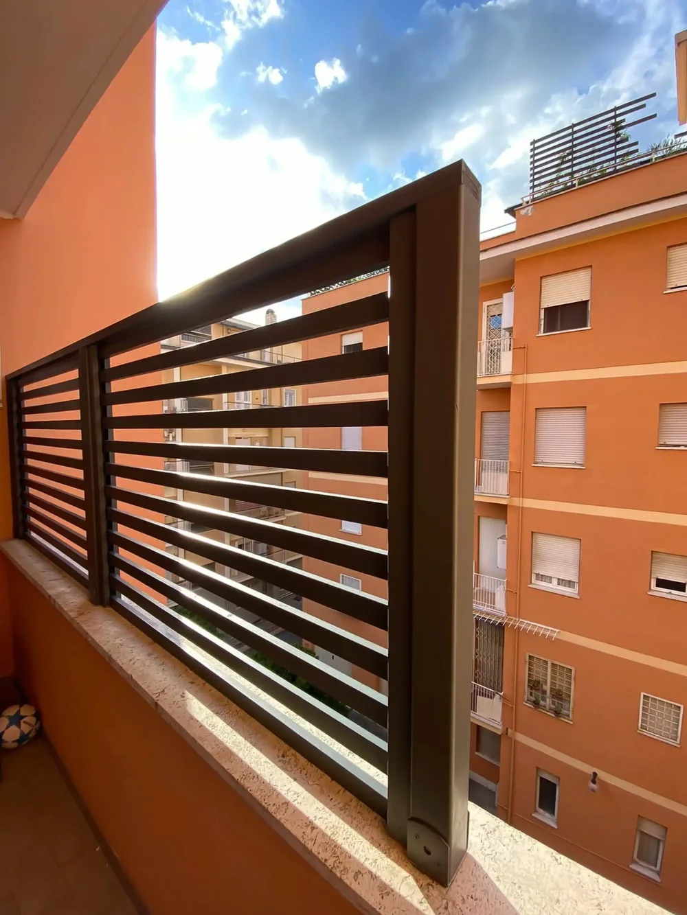 Un pannello grigliato in PVC per ombra e privacy su un balcone.