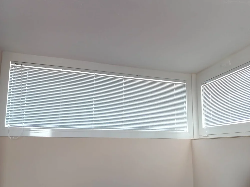 Vista frontale del processo di installazione della nostra cappottina in PVC a strisce blu e bianche sopra un ingresso