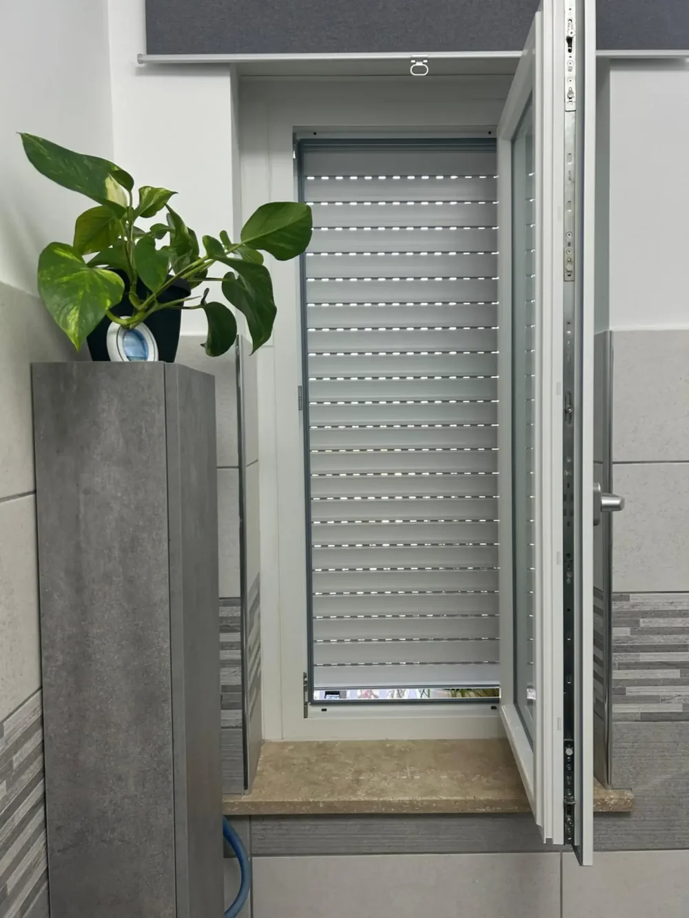 Vista frontale del processo di installazione della nostra cappottina in PVC a strisce blu e bianche sopra un ingresso