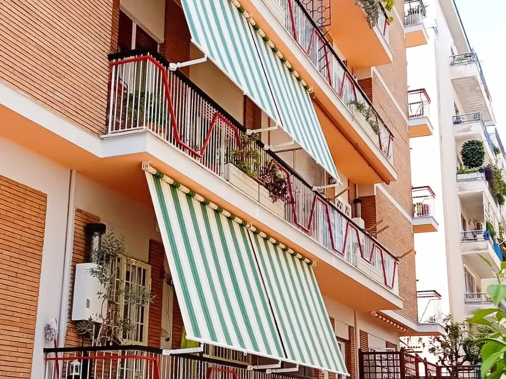 Appartamenti multipli con balconi con tende da sole a caduta a strisce verdi Tempotest a Roma.