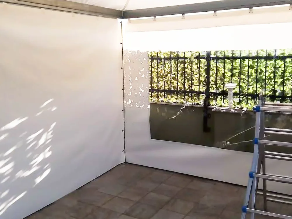 Vista interna di un gazebo bianco con chiusure perimetrali in PVC.