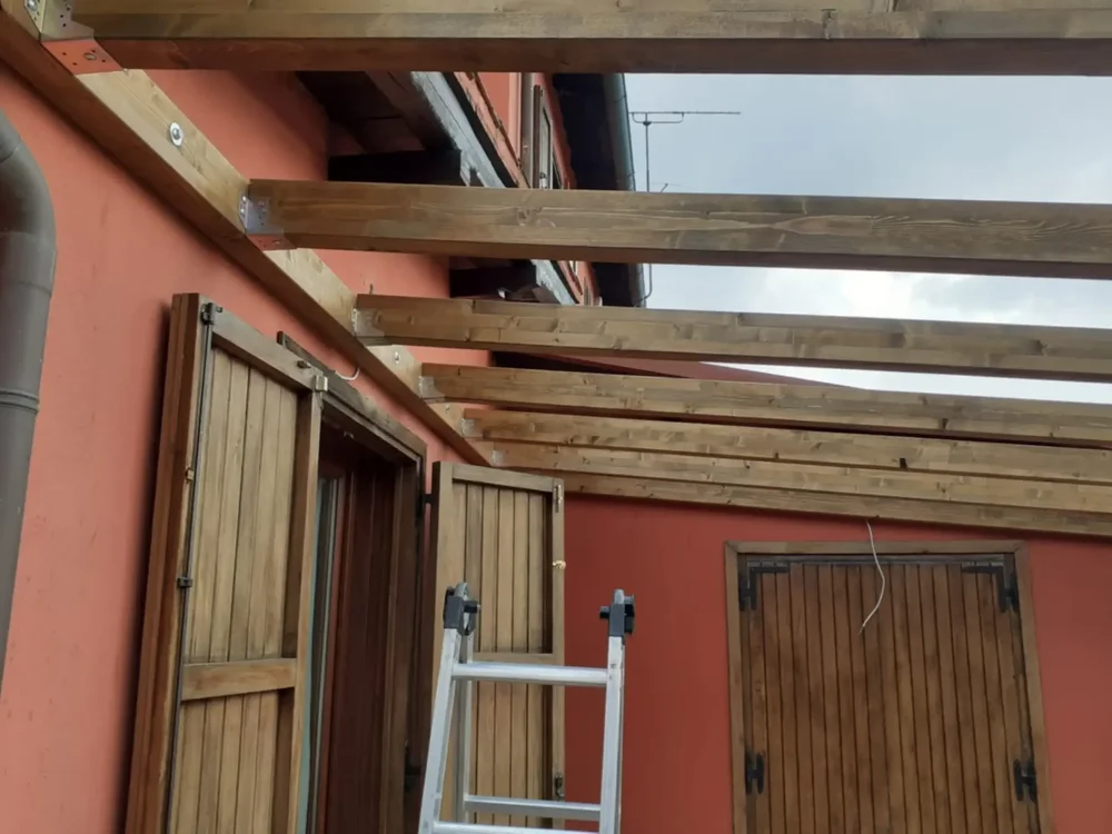 Primo piano travi in ​​legno lamellare per tettoie, al centro di un'installazione sopra l'ingresso.