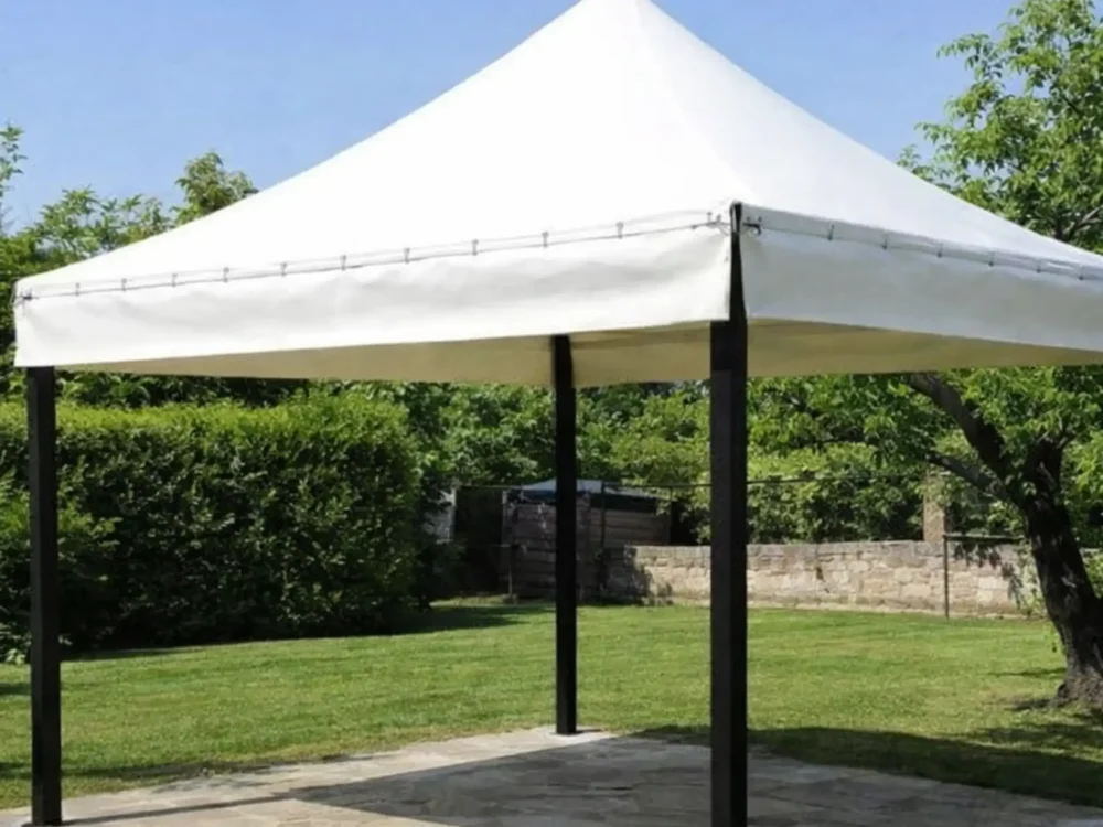 Modello di gazebo con tetto in PVC bianco e struttura in ferro nero all'interno di un giardino.