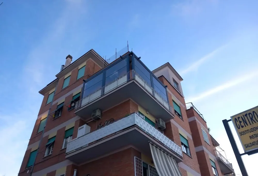 Chiusure laterali per balcone antivento e antipioggia, realizzate con parte superiore in PVC trasparente e fascia inferiore opaca per la privacy.