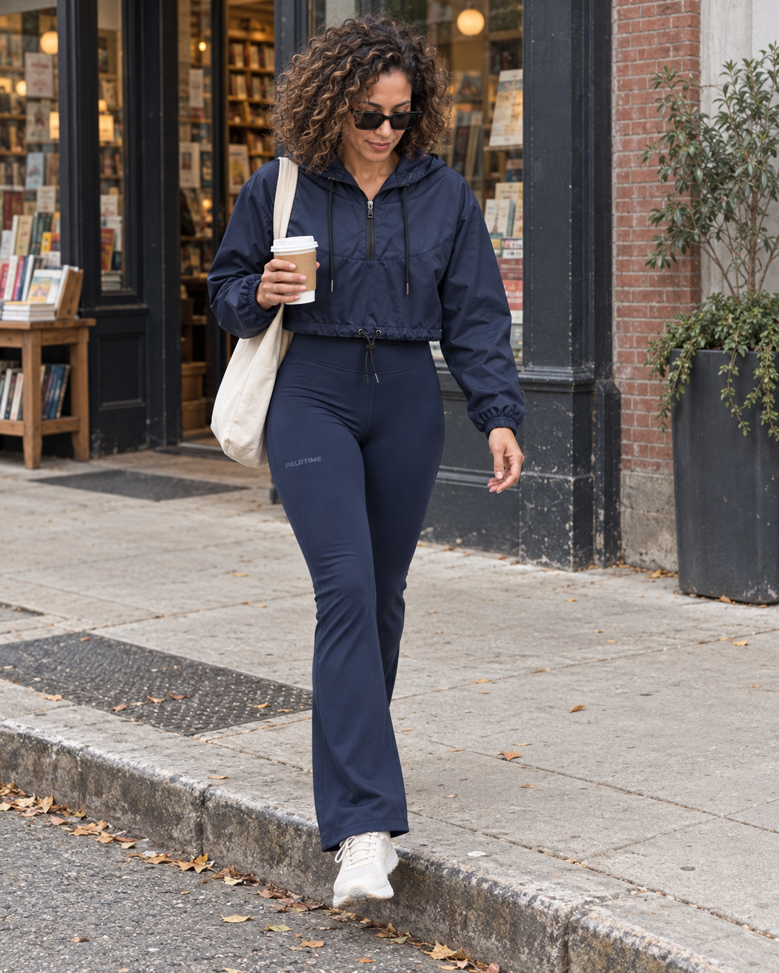 Woman wearing a navy Fieldtime windbreaker and flared leggings on an afternoon walk