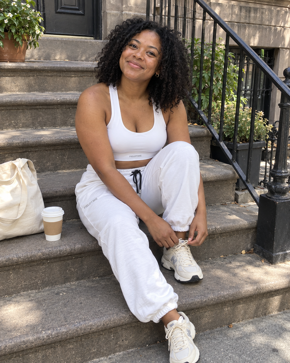 Candid stoop photo of a woman tying her shoes in white Fieldtime activewear