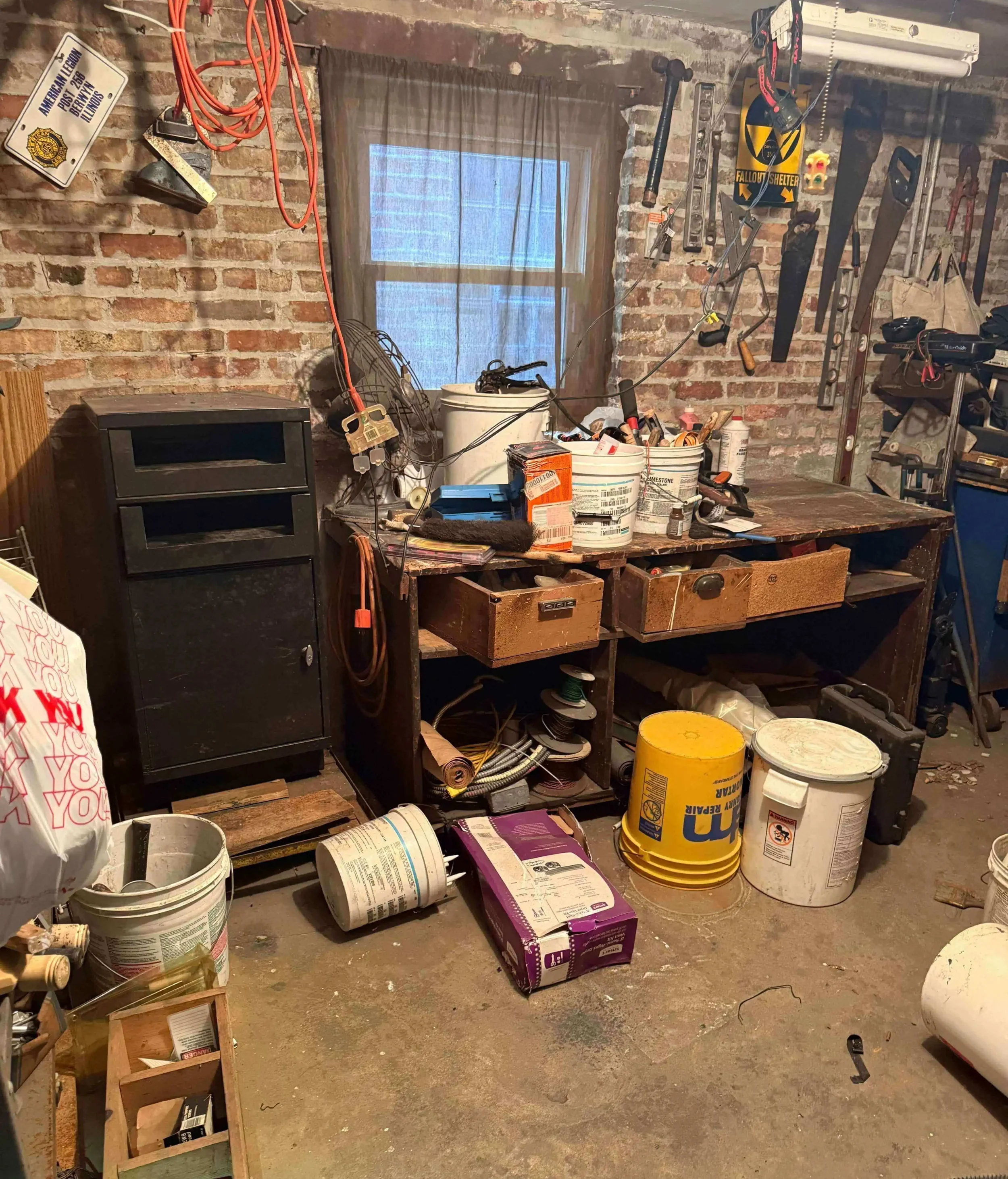 Unfinished basement storage area in Cicero, IL filled with old furniture and items.
