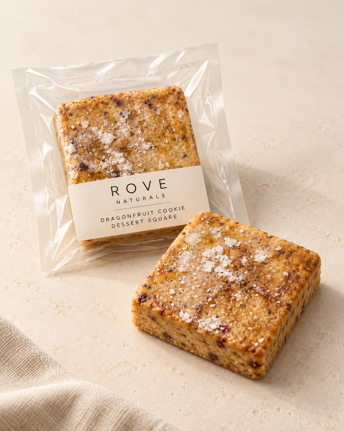 Rove dragonfruit cookie dessert square mockup, packaged and unwrapped on warm limestone.