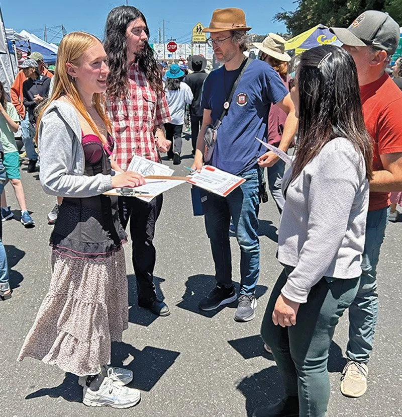 BAAP volunteer on a sunnny day at a street fair sign up new volunteers