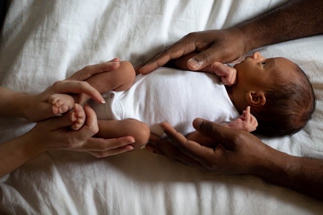 A newborn Indigenous baby held lovingly by their parents
