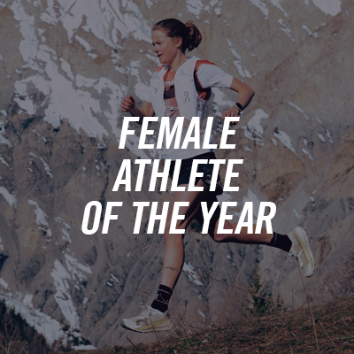 Female athlete running in the countryside with mountains in the background, wearing a white t-shirt, running jacket and backpack, in front of a text reading 'Female Athlete of the Year'.