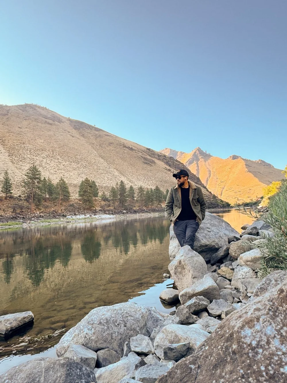Galen standing on rocks by a calm canyon river