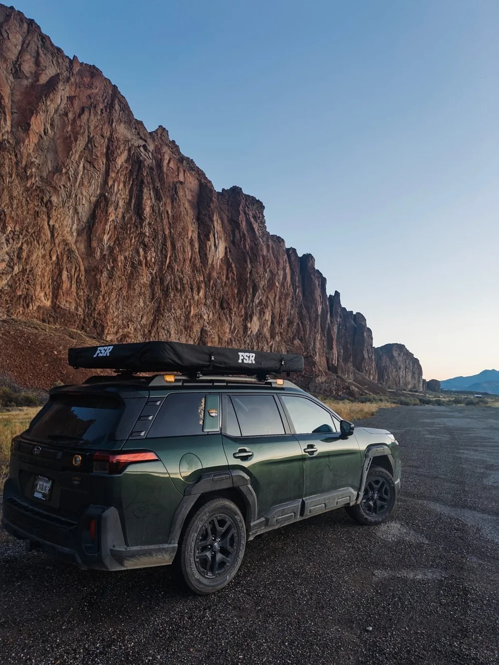 The Outback with its FSR rooftop tent below a red rock cliff