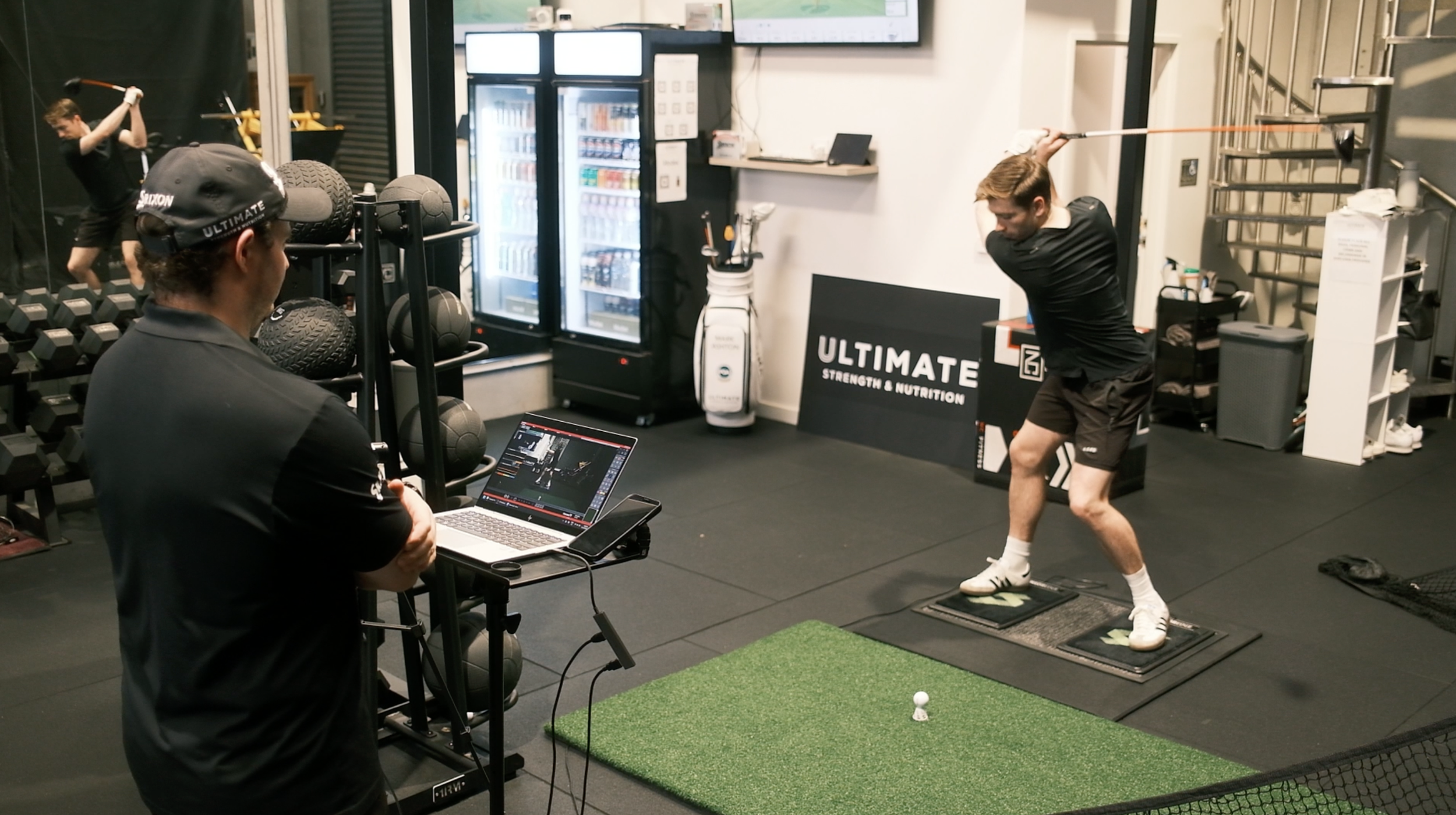An Ultimate Golf Performance coach analysing a golfer swinging on force plates