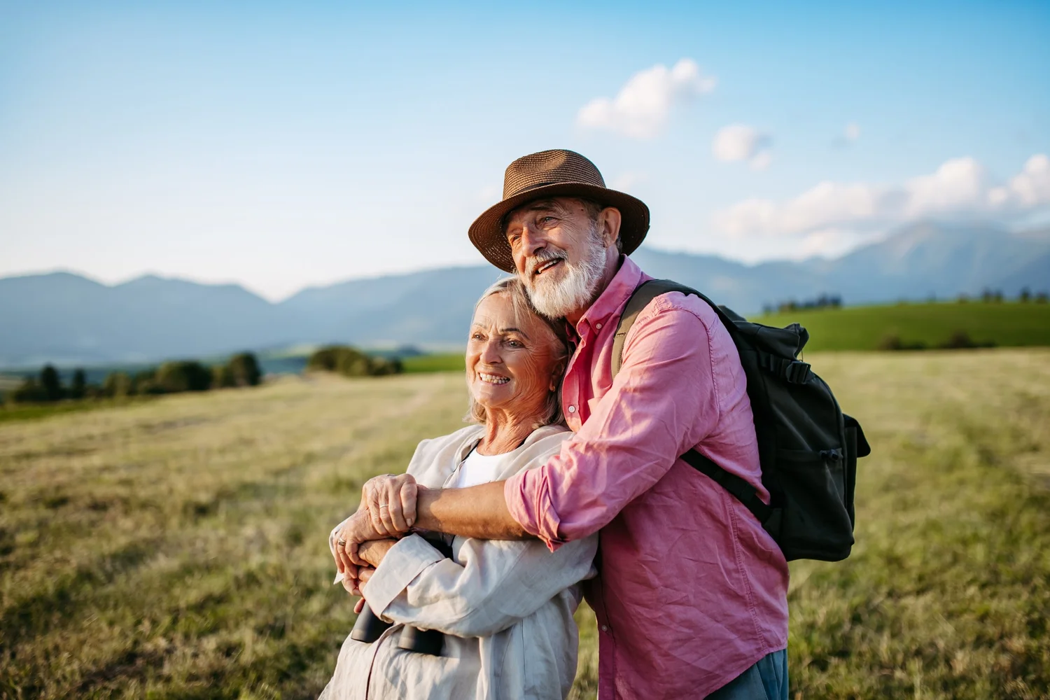 A couple in their sixties hiking in a mountain meadow