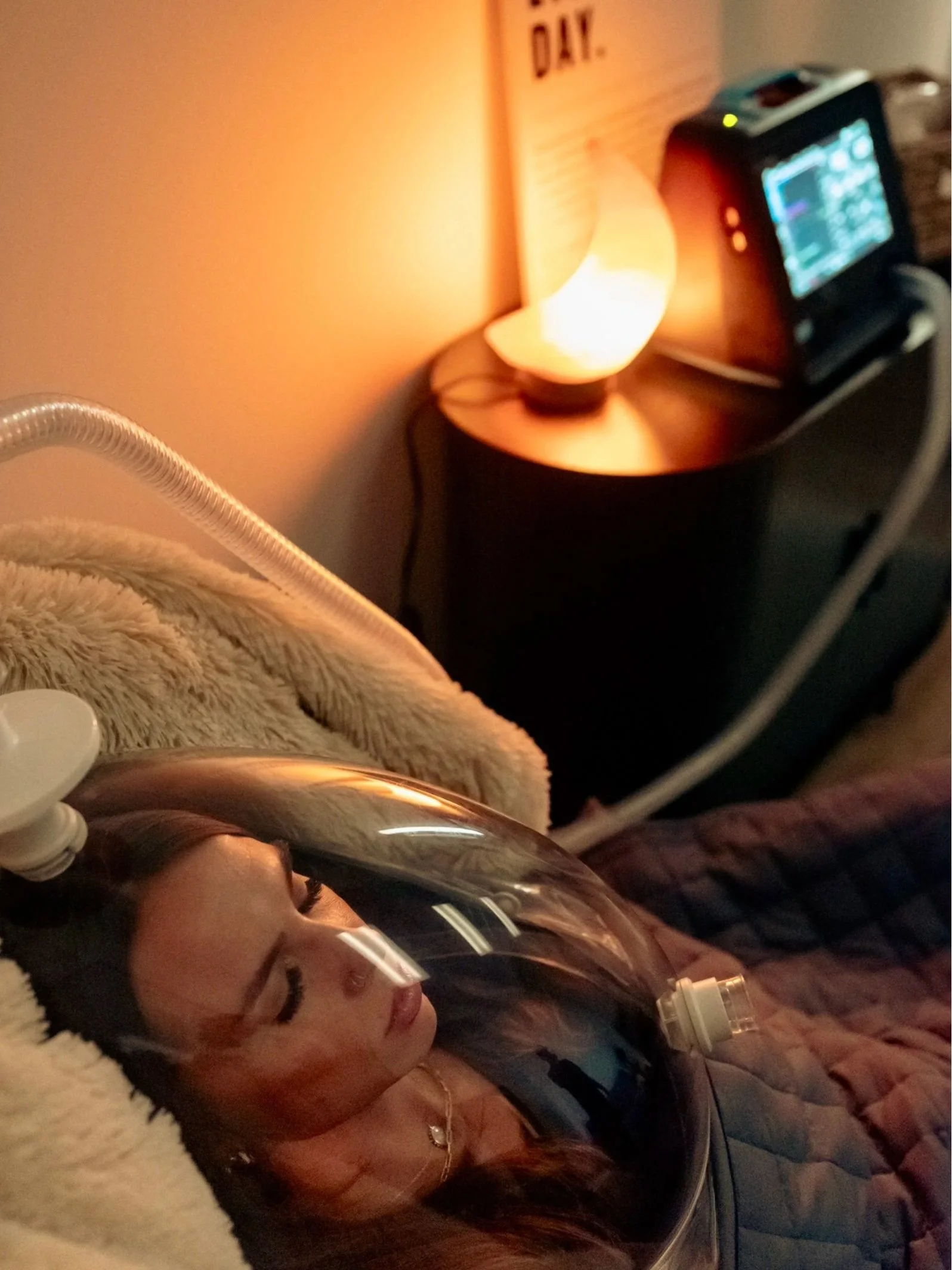 A client resting under the clear RMR canopy at DexaFit Greenville, covered with a weighted blanket